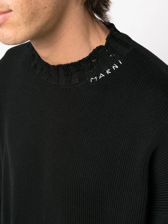 Close up of the black sweater, showing texture of the cotton fabric