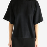 Black t-shirt worn by a person, showing the shirt's fit