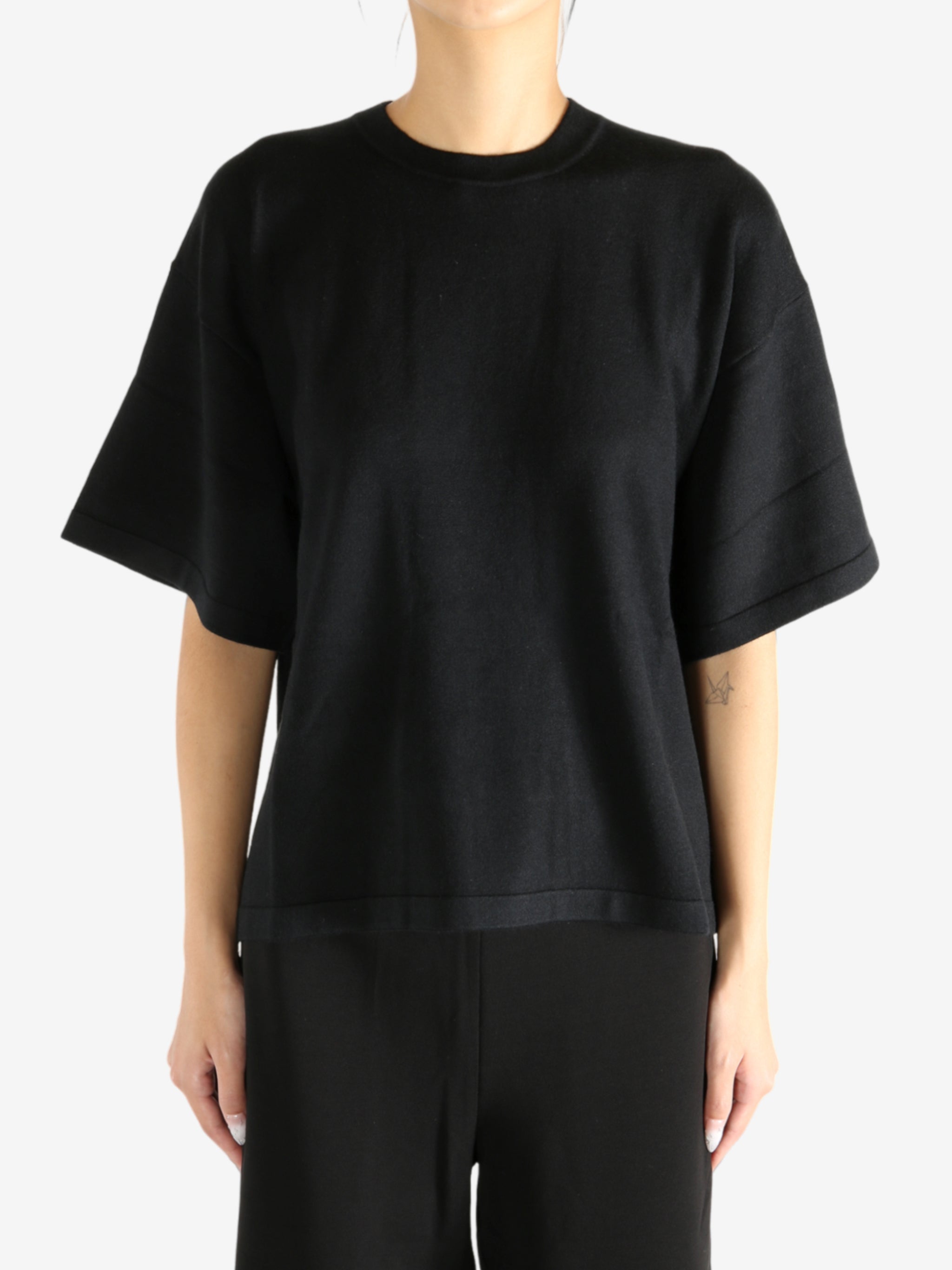 Black t-shirt worn by a person, showing the shirt's fit