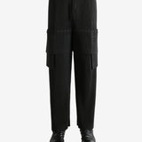 Black pants worn by a person, showing the pant's fit