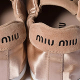 Close up of pink sneakers, showing texture of the rubber and satin calf suede fabric