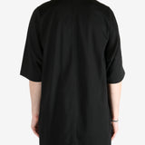 Black shirt worn by a person, showing the shirt's fit