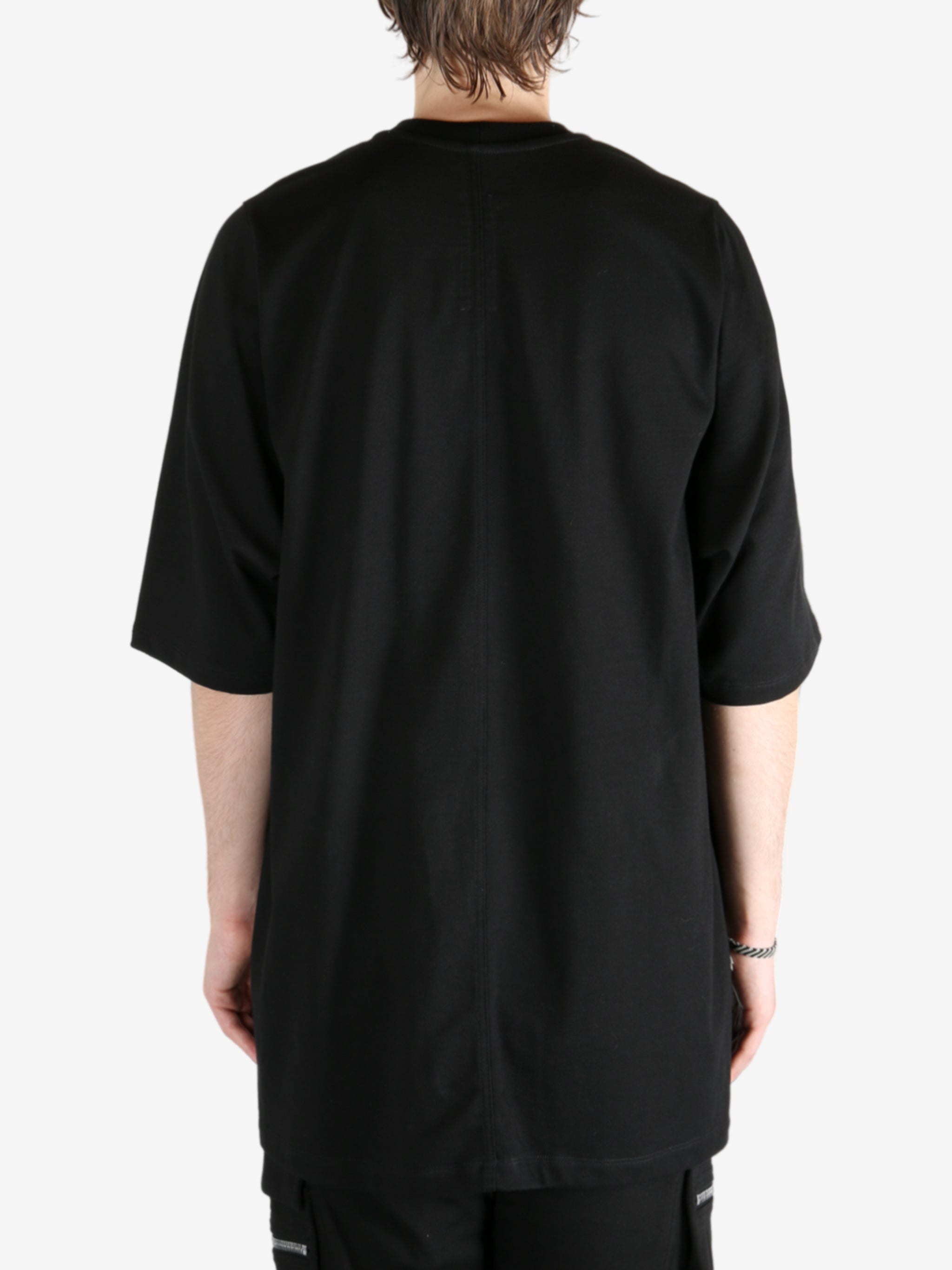 Black shirt worn by a person, showing the shirt's fit
