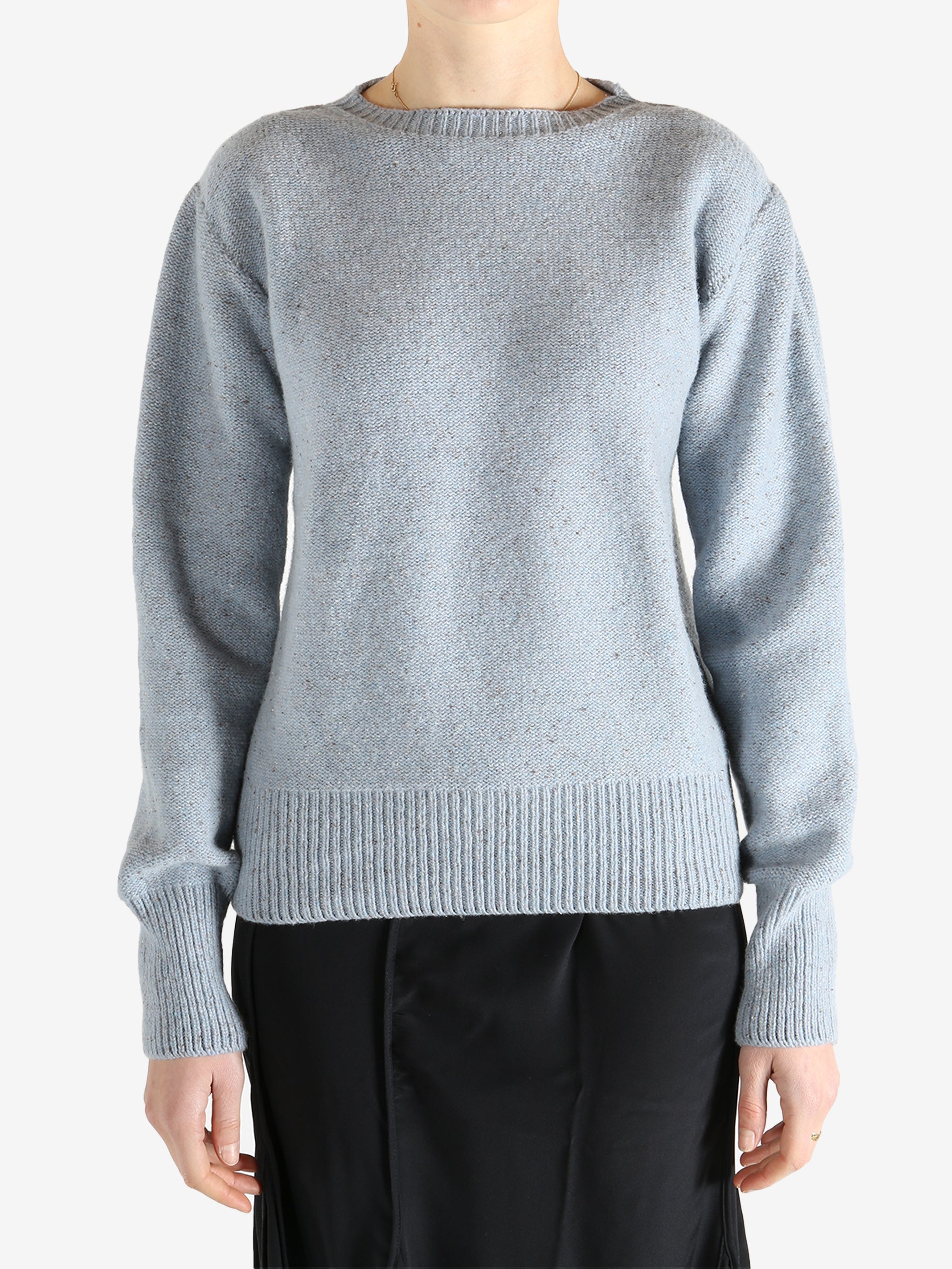 Blue sweater worn by a person, showing the sweater's fit