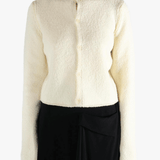 White cardigan worn by a person, showing the cardigan's fit