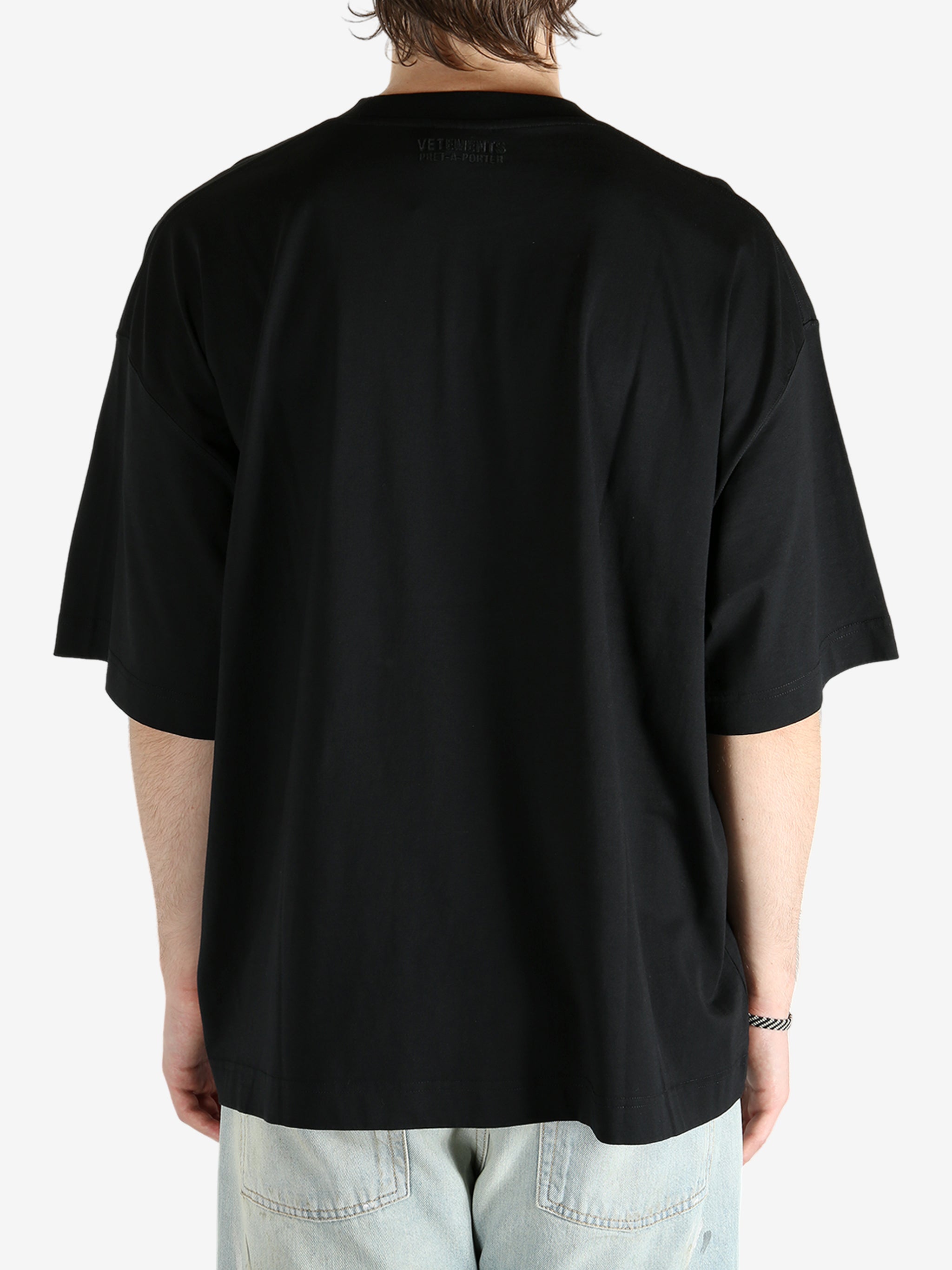 Black t-shirt worn by a person, showing the shirt's fit