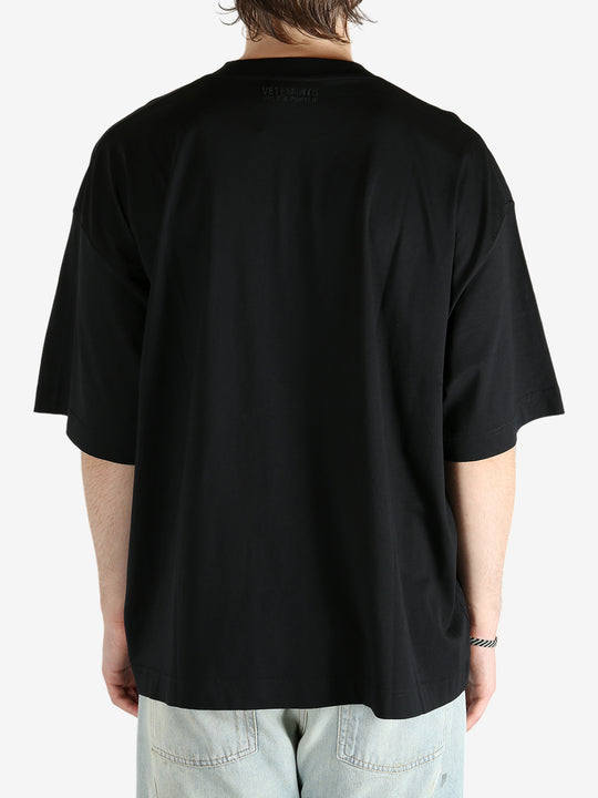 Black t-shirt worn by a person, showing the shirt's fit