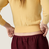 Yellow knitwear worn by a person, showing the knitwear fit