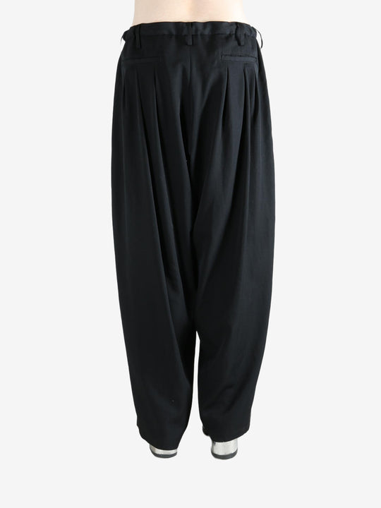 black pants worn by a person, showing the pants fit