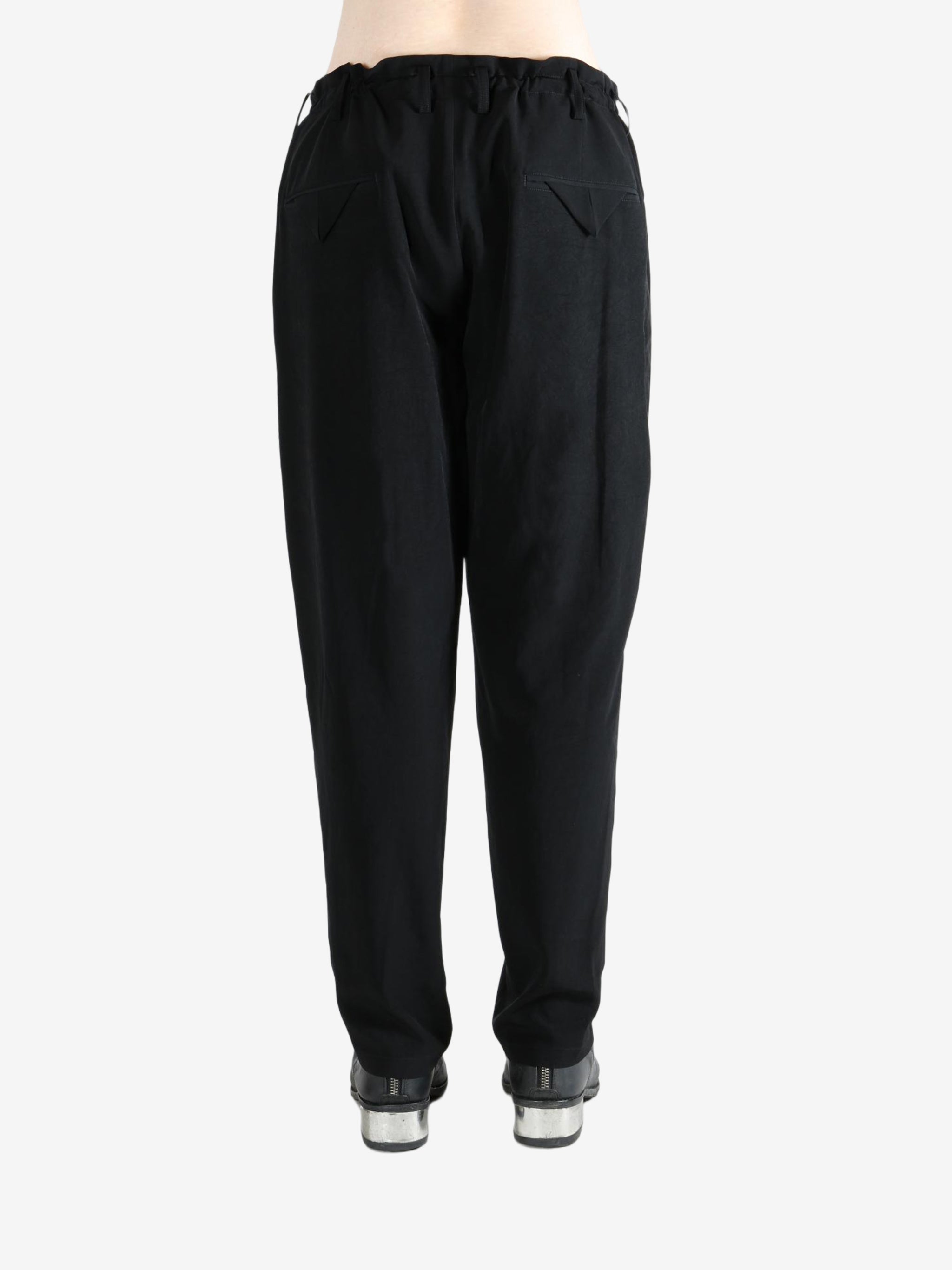 Black pants worn by a person, showing the pants's fit