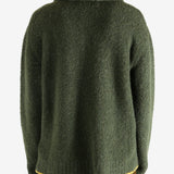 Green knitwear worn by a person, showing the knitwear's fit