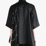 Black shirt worn by a person, showing the shirt's fit