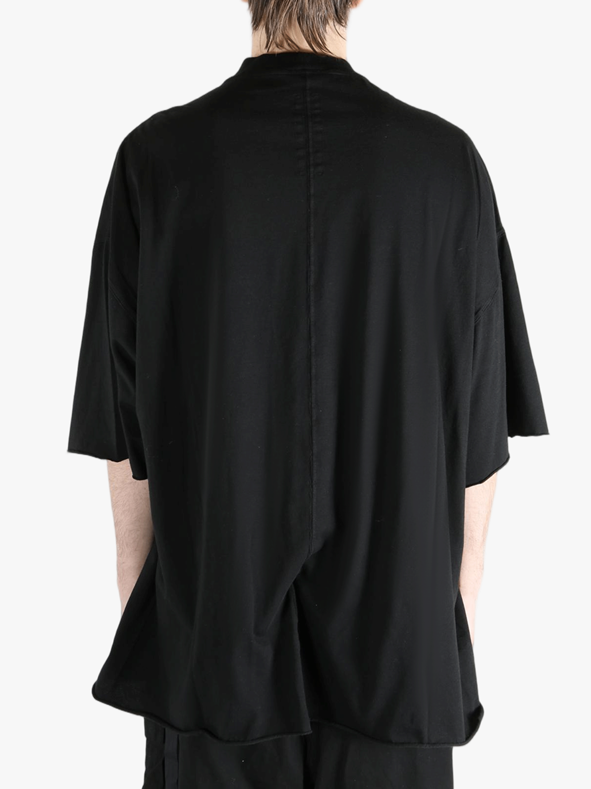Black t-shirts worn by a person, showing the t-shirts fit