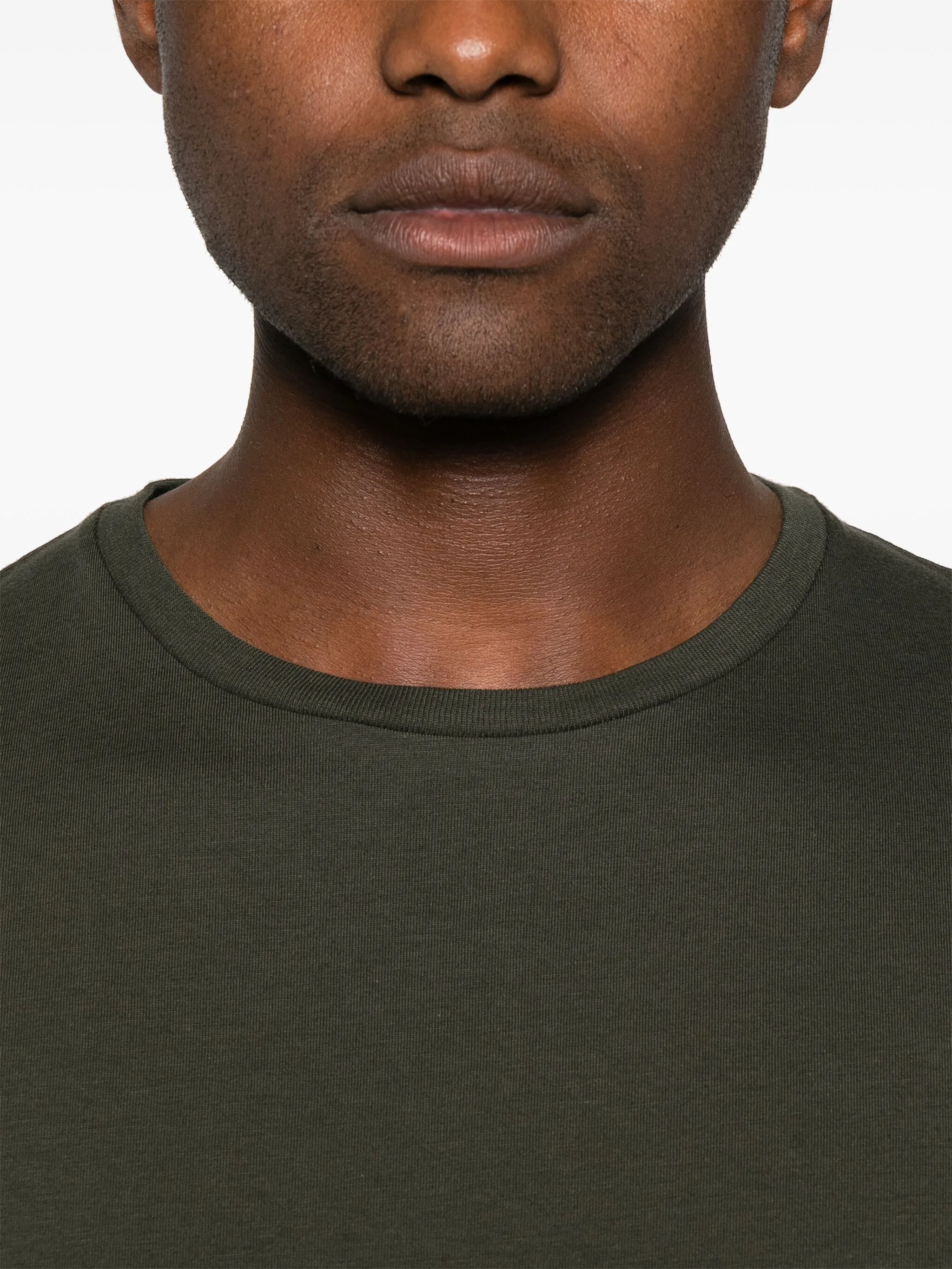 Close up of green t-shirt, showing texture of the cotton fabric