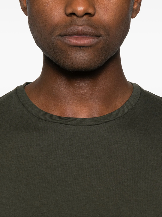 Close up of green t-shirt, showing texture of the cotton fabric