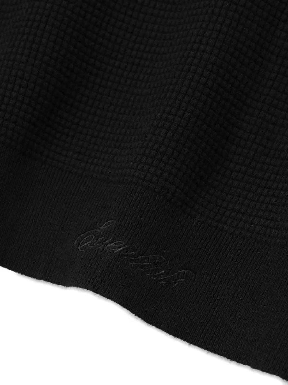 Close up of black sweater, showing texture of the polyester fabric