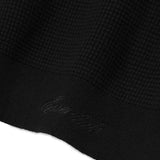 Close up of black sweater, showing texture of the polyester fabric