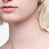 Yellow jewelry worn by a person, showing the jewelry fit