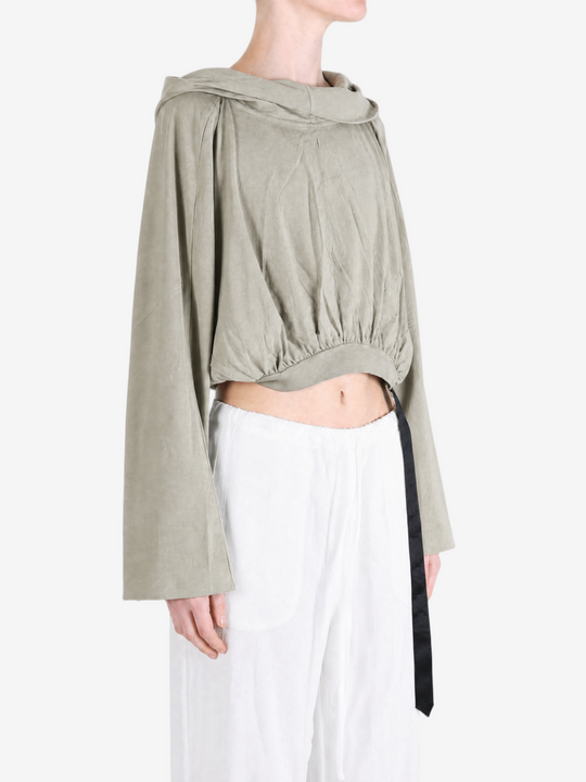 Green top worn by a person, showing the top fit
