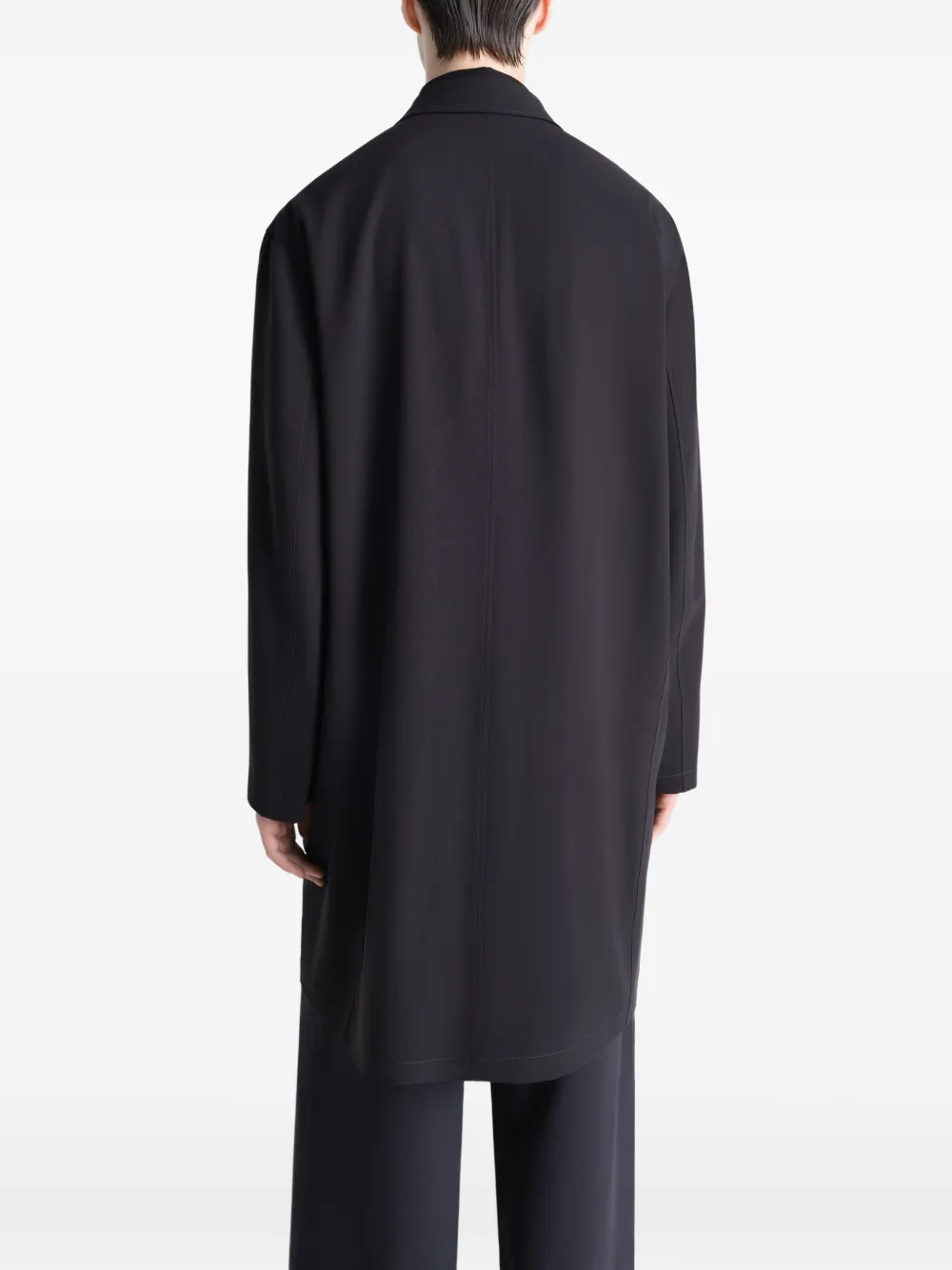 Black coats worn by a person, showing the coats fit