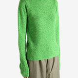 Green knitwear worn by a person, showing the knitwear fit