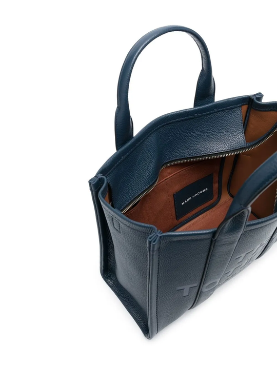 Close up of navy bags, showing texture of the leather fabric