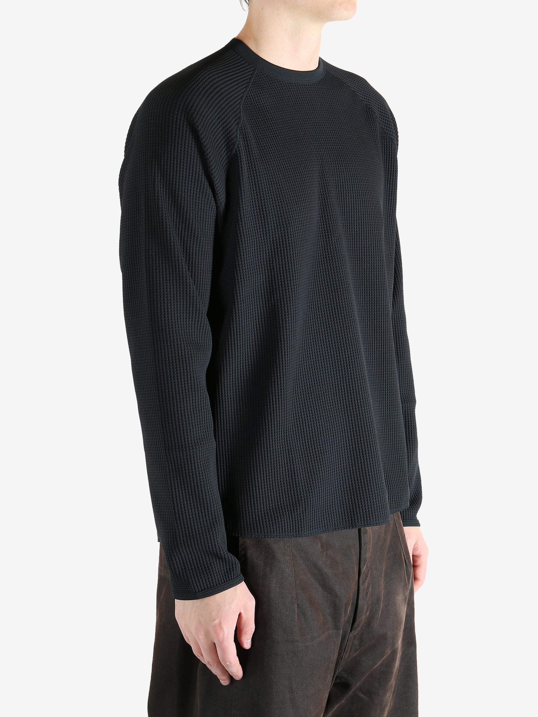 Black shirts worn by a person, showing the shirts fit