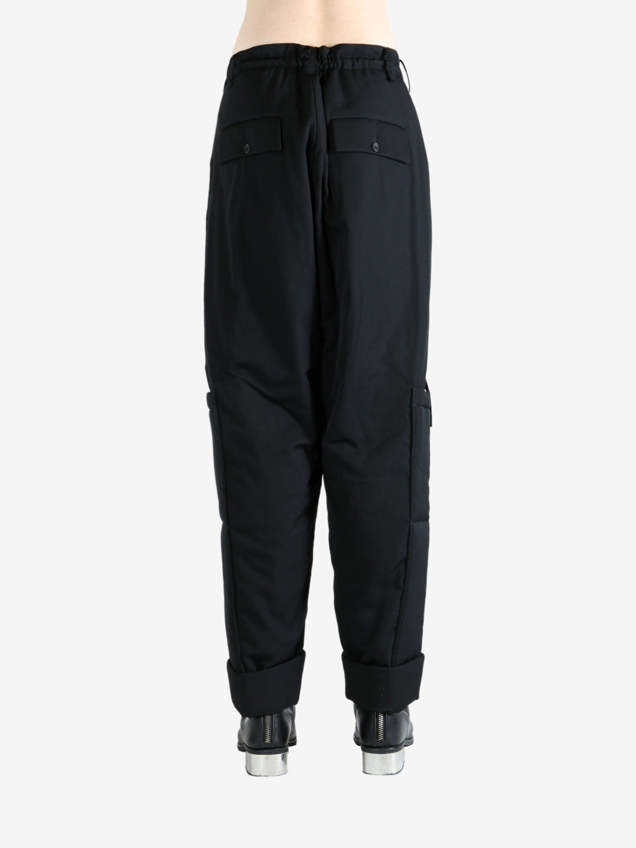 Black pants worn by a person, showing the pants' fit