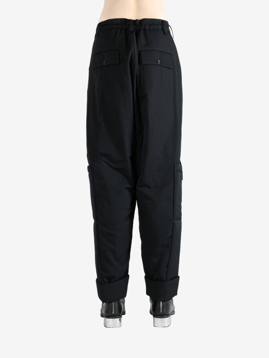 Black pants worn by a person, showing the pants' fit