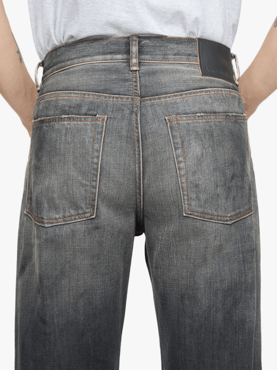 Black jeans worn by a person, showing the jeans fit