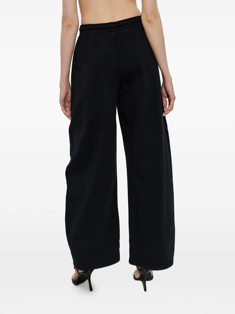 Black pants worn by a person, showing the pants' fit