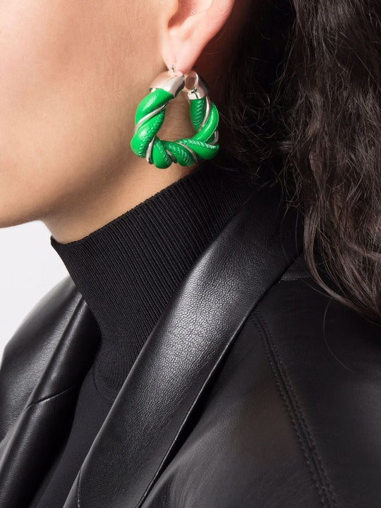 Green earrings worn by a person, showing the earrings fit